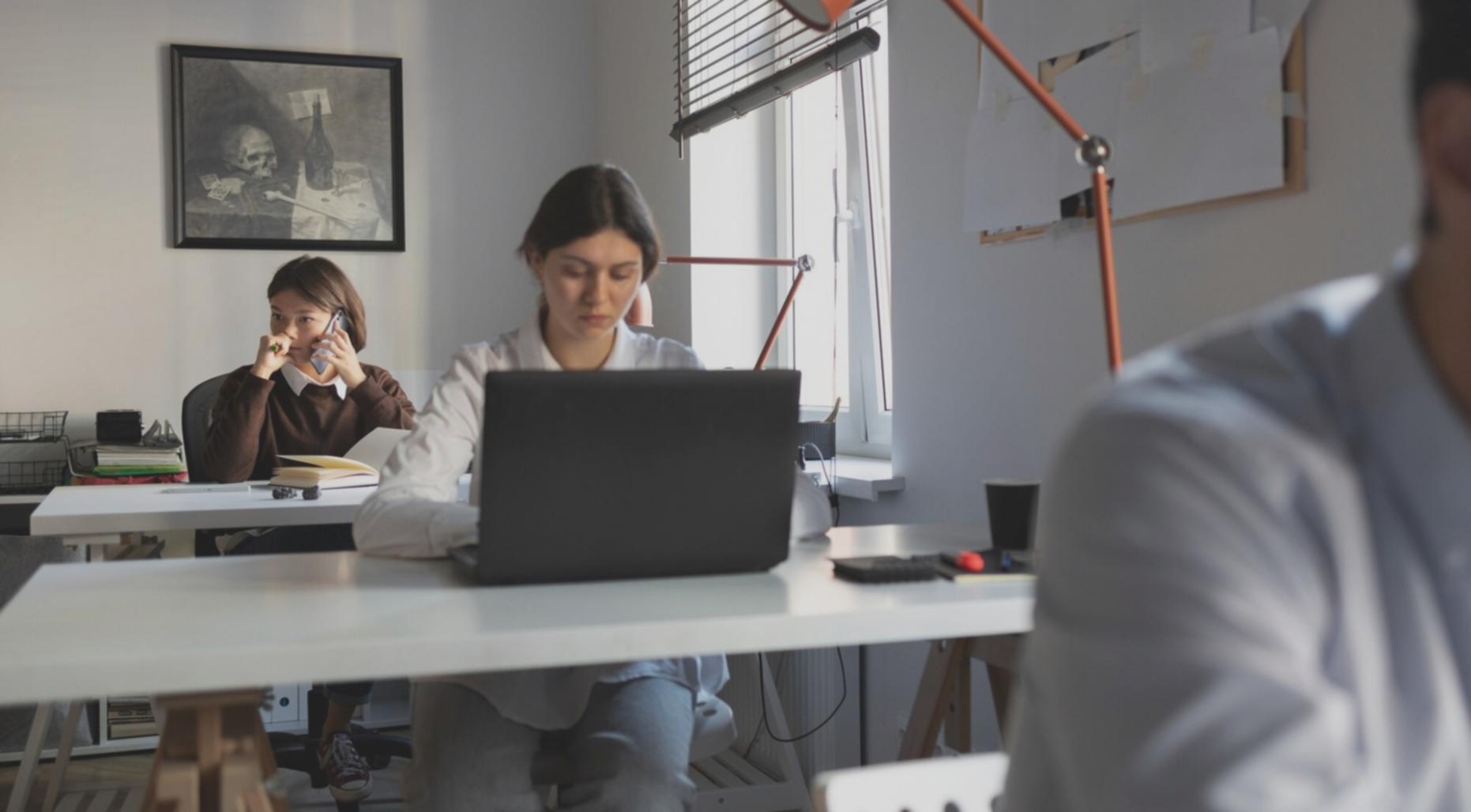 Konzentrierte Studentin bei der Heimarbeit mit strukturiertem Arbeitsplatz